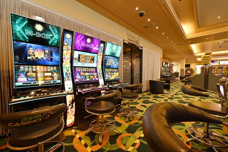 Reihe von M BOX Spielautomaten im Innenbereich des Ring Casino mit Drehhockern