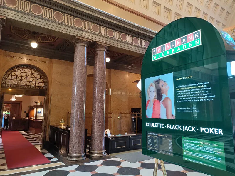 Foyer der Spielbank Wiesbaden mit Marmorsaeulen Registrierungstheke und einem Schild