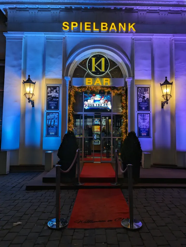 Beleuchteter Eingang zur Spielbank Wiesbaden bei Nacht mit rotem Teppich